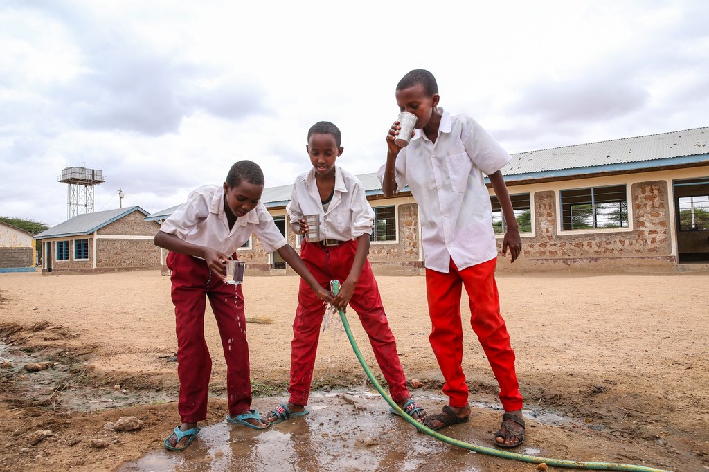 Osman (11), Abdullahi (15) y Abdi (12), de la escuela primaria de Daley, en Kenia, beben agua limpia y salubre procedente del pozo solar de la aldea, que cuenta con el apoyo de UNICEF.